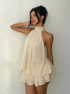 Close-up of layered pleated chiffon hem on a cream halter vacation dress