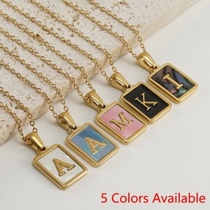 Colliers avec pendentifs lettres en acier inoxydable et nacre sur socle en pierre
