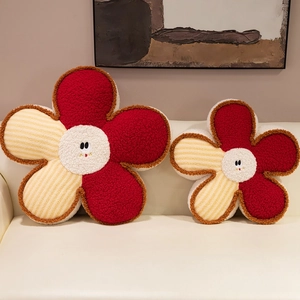 Smiling flower plush cushions in red and yellow stripes on a white sofa decor