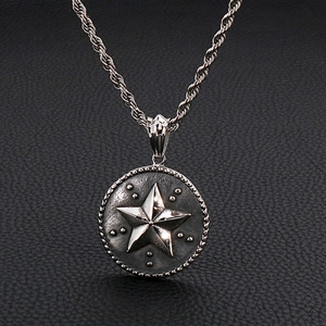 Gros plan d'un collier en acier titane argenté avec pendentif rond étoile sur cuir noir