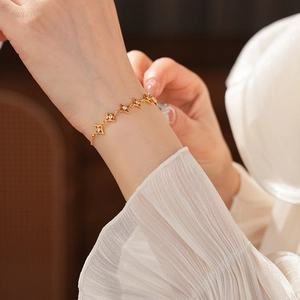 Détail d'un bracelet étoile plaqué or 18k avec zircons blancs sur le poignet