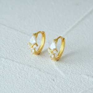 Macro detail of S925 silver gold-plated earrings with drop and square cut cubic zirconia