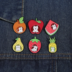 Close-up of cute cartoon cat fruit enamel pins on denim fabric showing detail