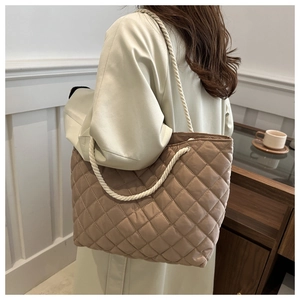 Détail d'un sac cabas en nylon matelassé avec poignées en corde et motif à losanges