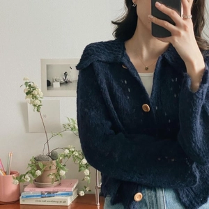 Detail of navy blue knit cardigan with large collar, hollow pattern and wooden buttons