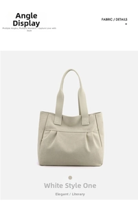 Detail view of large beige canvas tote bag with wide shoulder straps and natural folds