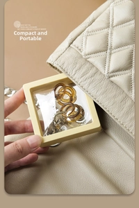 Macro shot of compact beige PE film jewelry box showing transparent earring display