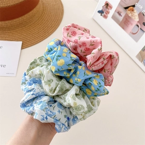 Close-up of assorted floral fabric scrunchies with pink rose and blue flower patterns