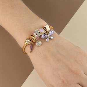 Detailed close-up of golden wire bracelet featuring purple crystal butterfly and beads