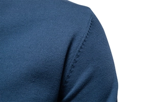 Macro shot of dark blue knit sweater showing refined shoulder seams and fabric texture