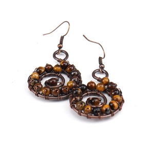 Detail of handmade bronze wire-wrapped earrings featuring natural tiger eye stone beads