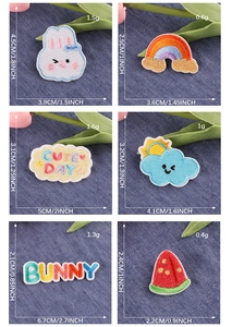 Detailed view of assorted cartoon bunny and rainbow embroidery patches on denim background