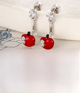 Detail of red enamel apple stud earring with zircon inlay and surgical steel barbell