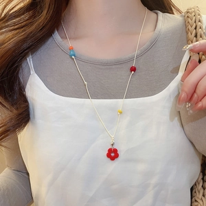 Detail of handmade beaded flower pendant necklace on model showing color beads
