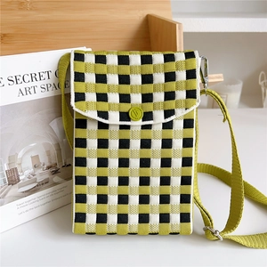 Detail of knitted checkerboard mini bag showing textured fabric and green button