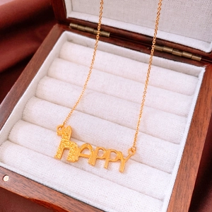 Macro detail of gold plated HAPPY pendant with animal silhouette on wood jewelry box