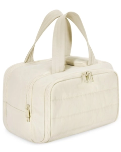 Close-up of cream quilted nylon toiletry bag featuring double zippers and top handles