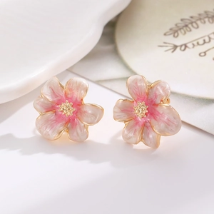Makroaufnahme von Kirschblüten-Ohrsteckern mit rosa-weißem Farbverlauf und Goldmitte