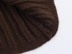 Detailed close-up of dark brown chunky knit fabric texture for autumn sets
