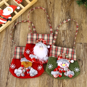 Christmas non-woven gift bags set with Santa, Reindeer, and Snowman designs on wood floor