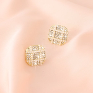 Elegant gold square stud earrings with white pearls and sparkling pavé diamonds on pink silk