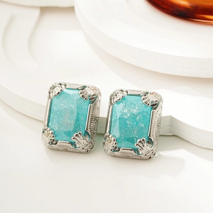 Macro shot of silver frame stud earrings with ice blue crystals and vintage carving