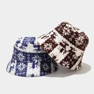 Close-up of winter bucket hats featuring festive reindeer and snowflake fleece patterns
