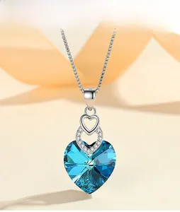 Detailed close-up of the heart-shaped blue crystal pendant with delicate silver pavé accents