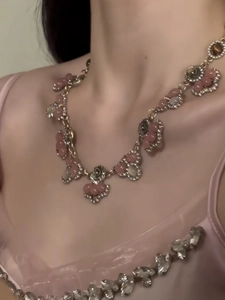 Detailed view of vintage gold flower necklace with pink beads and rhinestones on model