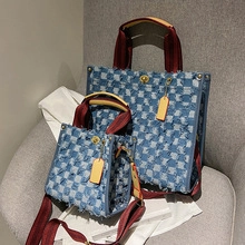 Detail of patchwork denim tote bag with frayed checkerboard design and turn-lock closure