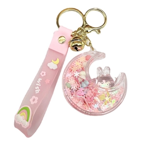 Pink quicksand moon bunny keychain with floating glitter and golden bell on white background
