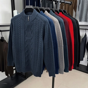 Men's half-zip cable knit sweaters displayed in multiple colors on a retail rack
