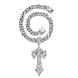 Detailed close-up of a silver-toned hip hop cuban chain necklace with iced out cross pendant