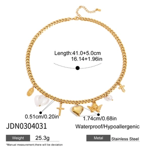 Détail du collier à grosse chaîne en acier doré 18 carats avec breloques cœur et croix