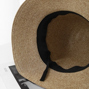 Gros plan d'un chapeau de paille tressé avec texture fine et bandeau réglable à l'intérieur