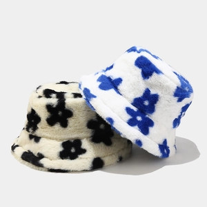 Detail of plush floral bucket hats in blue and black flower patterns for winter