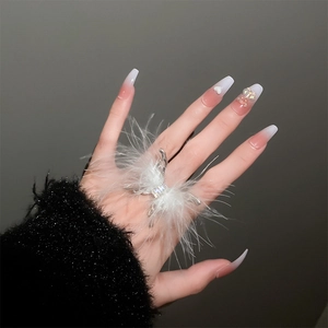 Detailed view of silver butterfly ring with white feathers and sparkling rhinestone center