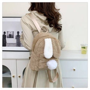 Rear view of a khaki plush rabbit backpack with white ears and a soft pom-pom tail