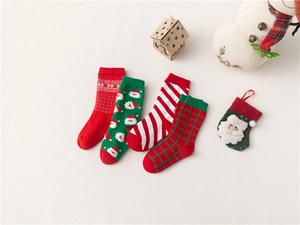 Close-up of four festive Christmas socks with Santa, snowflake, and plaid patterns