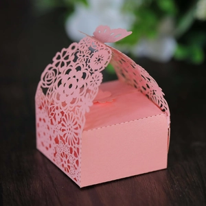 Macro shot of laser-cut butterfly wedding candy box with intricate floral hollow pattern