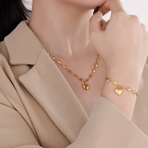 Golden heart-shaped necklace and bracelet set shown on model for elegant style