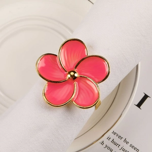 Pink five-petal flower napkin ring with gold edges on white napkin for wedding table decor