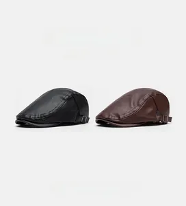 Detailed side view of black and brown leather flat caps with metal adjustment buckles