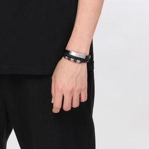 Macro detail of multi-layer braided leather bracelet with brushed metal beads