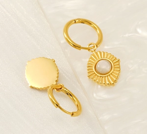 Macro detail of 18K gold-plated stainless steel earrings with cat-eye stone sunburst