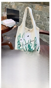 Detail of chamomile print canvas tote bag featuring snap button and inner zipper pocket