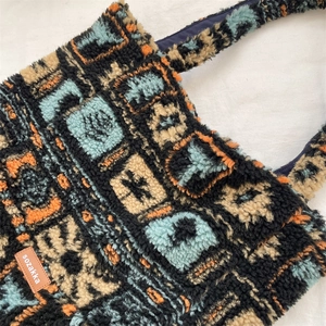 Detail of vintage plush tote bag featuring colorful geometric patterns and leather label