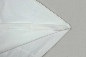 Detail of white dress showing professional stitching and breathable mesh fabric texture
