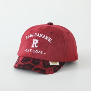 Detail of red faux suede kids baseball cap featuring leopard print brim and embroidery