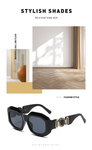 Detail of stylish black sunglasses featuring luxury gold ring hardware on the temples